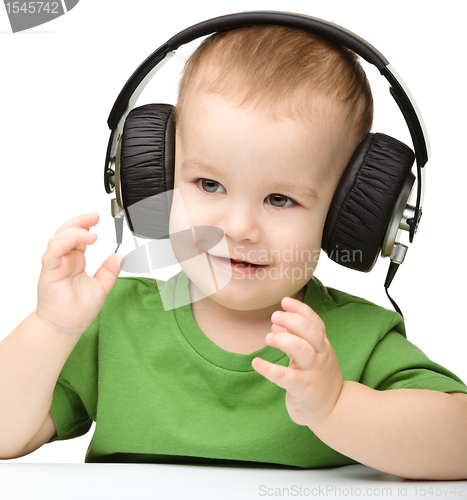 Image of Cute boy enjoying music using headphones