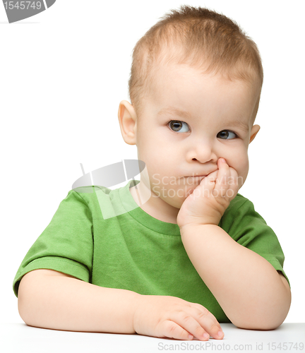 Image of Pensive little boy support his head with hand
