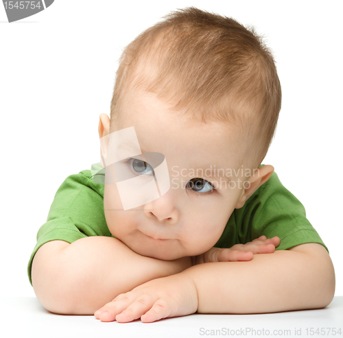 Image of Pensive little boy support his head with hands