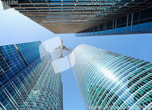 Image of Airliner flying over skyscrapers