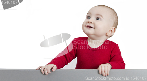 Image of young child standing at grey cardboard