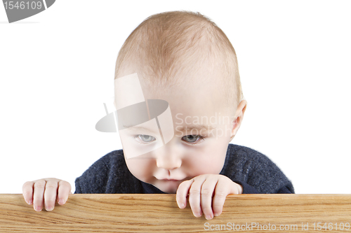 Image of young child holding wooden board