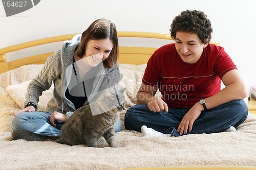 Image of Young couple playing with their kitten