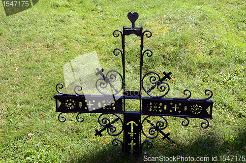 Image of Metal decorative cross in meadow partisan cemetery 