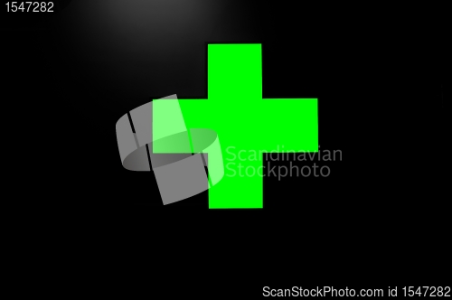 Image of Green cross on black background with a little light