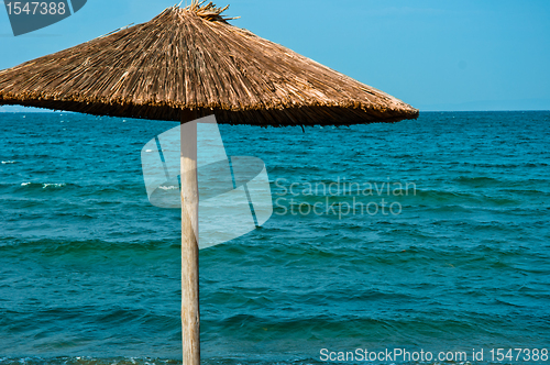 Image of Umbrella against blue ocean 