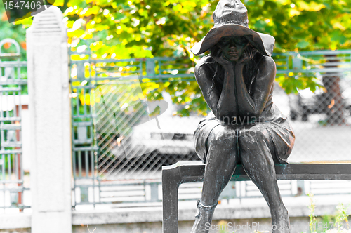 Image of Woman made out of stone sitting in the park