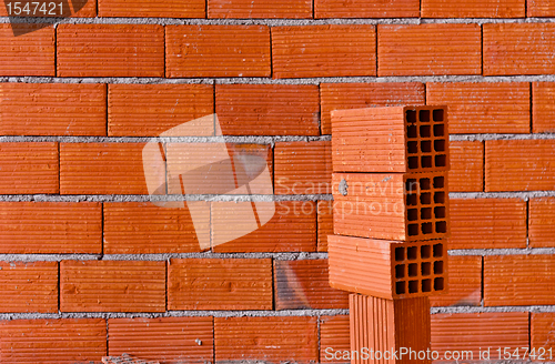 Image of Brick wall with a stack of new bricks