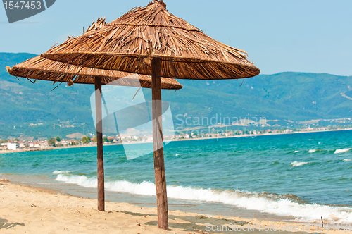 Image of Umbrellas on the beach with mountan and ocean