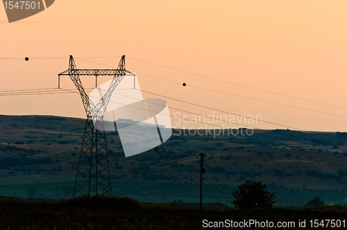 Image of Hihg voltage post against sky at dusk