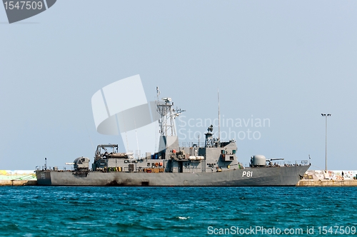 Image of Big battle ship in the dock against blue sky and mountains