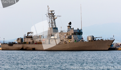 Image of Big battle ship in the dock against blue sky and mountains