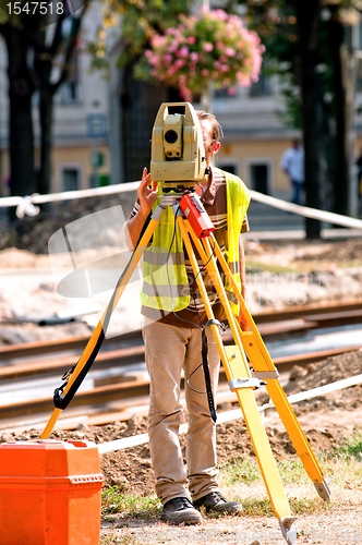 Image of Worker inspecting site  with his tripod and industrial device