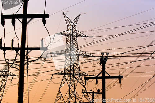 Image of Hihg voltage post against sky at dusk