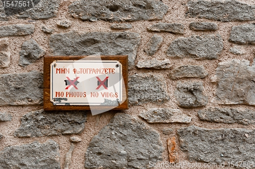 Image of Do not take photos sign on stone wall