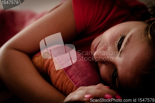 Image of Young beautiful girl lying in bed