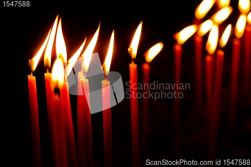 Image of Red candles in a row glowing