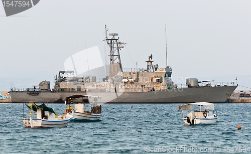 Image of Big battle ship in the dock against blue sky and mountains