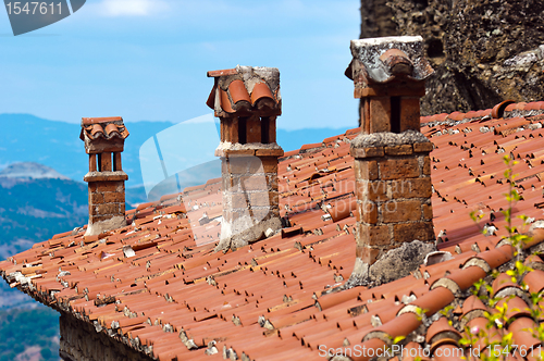 Image of A rooftop with chimney against blue sky