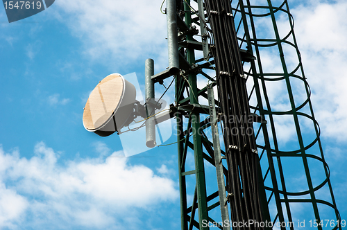 Image of Communication tower against blue sky with clouds