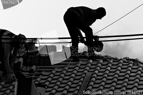 Image of Industrial workers in hard work on the roof