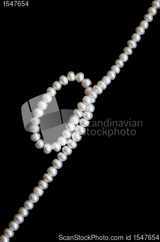 Image of White pearls on the black silk 