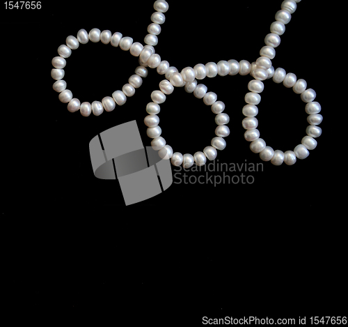 Image of White pearls on the black silk 