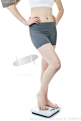 Image of Fit woman standing on bathroom scale