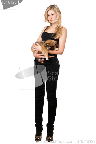 Image of Pretty woman in black pants holding puppy