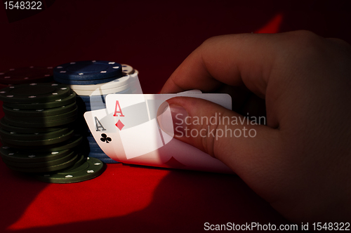 Image of Two aces high on red table with chips