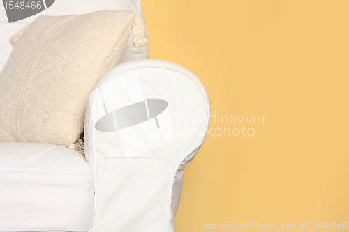 Image of white couch near yellow wall