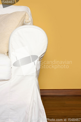 Image of white couch near yellow wall