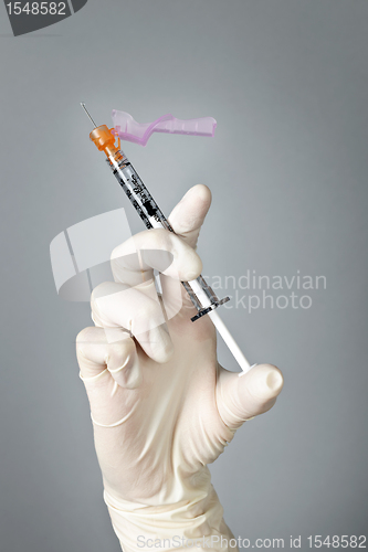 Image of Syringe held by gloved hand