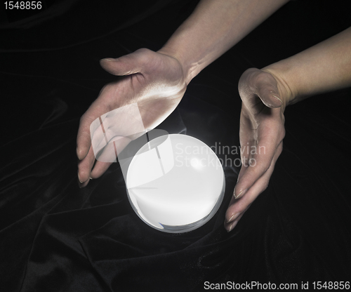 Image of crystal ball and hands around