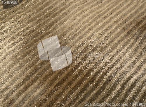 Image of drilled lines in brown sand surface