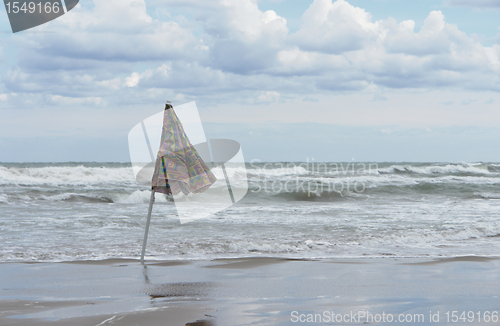 Image of closed sunshade and deserted beach