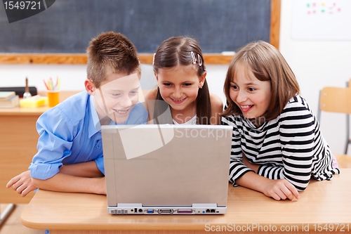 Image of Happy kids looking at laptop
