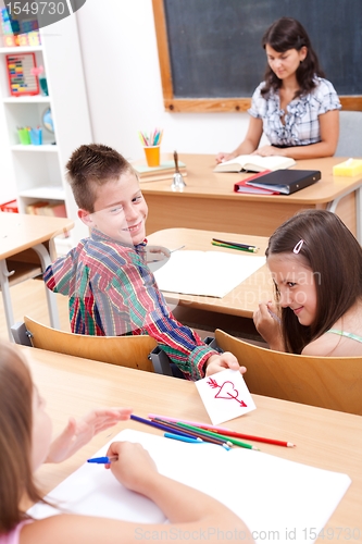 Image of Elementary school boy giving love letter to his colleague