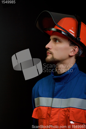 Image of The worker in overalls and a helmet