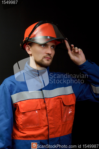 Image of The worker in overalls and a helmet