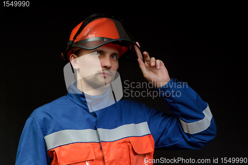 Image of The worker in overalls and a helmet