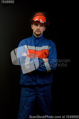 Image of The worker in overalls and a helmet