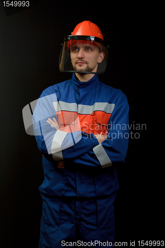 Image of The worker in overalls and a helmet