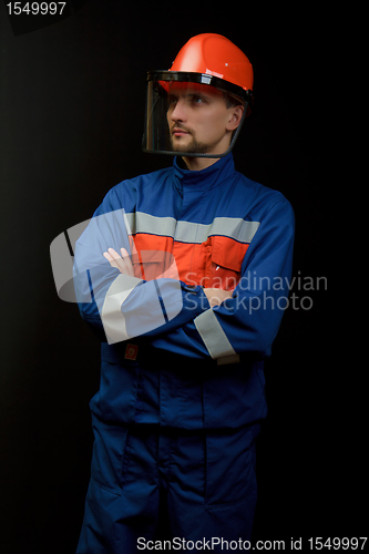 Image of The worker in overalls and a helmet