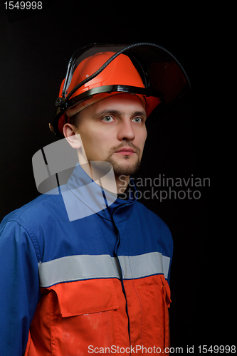 Image of The worker in overalls and a helmet