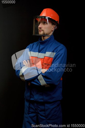 Image of The worker in overalls and a helmet