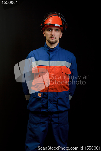 Image of The worker in overalls and a helmet