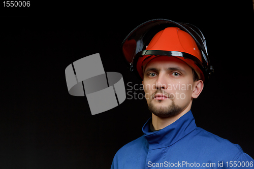 Image of The worker in overalls and a helmet