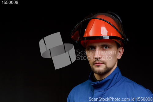 Image of The worker in overalls and a helmet