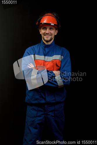 Image of The worker in overalls and a helmet